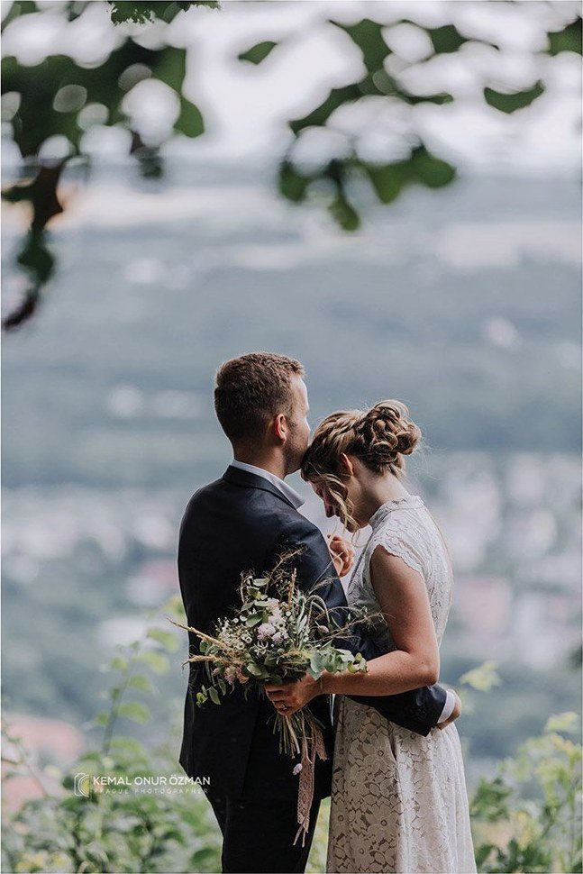 Bride and groom with a wildflower bouquet above the city