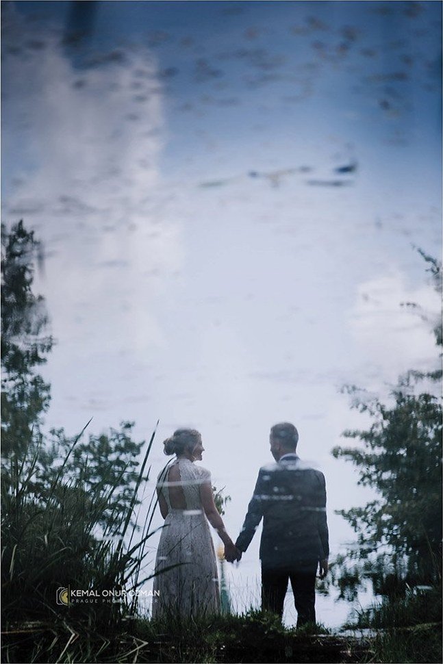 Couple holding hands reflected in still water